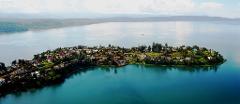 Lakes and Lowland Gorillas from Bukavu A scenic aerial shot of an island community nestled on a lake surrounded by rolling hills.