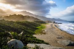 A beautiful beach landscape with lush vegetation, mountains in the background, and dramatic lighting.