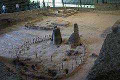 An indoor archaeological site displays ancient ruins with elevated walkways for visitors.