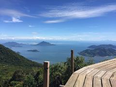 A scenic overlook with lush green islands in a blue ocean under a sunny sky with wispy clouds.