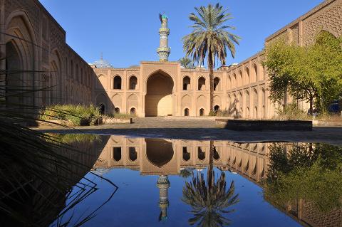 The Abbasid Palace in Baghdad reflects beautifully in the still water of the courtyard.