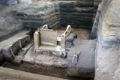 This is an archeological site, possibly an ancient dwelling or structure, with layers of earth and excavation revealing preserved architecture.