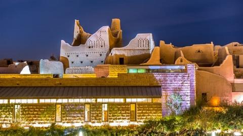 A night view of Al-Turaif District in Riyadh, Saudi Arabia, showcasing its historical mud-brick architecture with modern lighting, blending heritage with contemporary design.