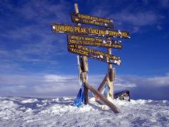 A signpost stands tall on the snowy summit of Uhuru Peak, Mount Kilimanjaro, celebrating the accomplishment of reaching Africa's highest point at 5895m AMSL.