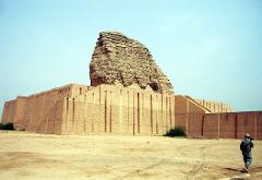 A ziggurat stands in a desert landscape, with a soldier walking in the foreground.