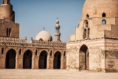 Tämä kuva näyttää Sultan Hassanin moskeija-madrassan, monumentaalisen moskeijan ja madrasan, joka sijaitsee Kairon historiallisessa kaupunginosassa Egyptissä. Se esittelee vaikuttavaa arkkitehtuuriaan ja yksityiskohtaista käsityötaitoaan.