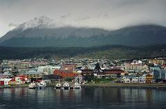 A coastal city nestled against a backdrop of mountains shrouded in mist.
