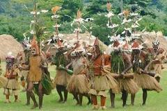 A group of people in traditional Papua New Guinean costumes are performing a ritual dance.
