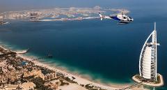 An aerial view shows a helicopter flying near the Burj Al Arab hotel and the Jumeirah coastline in Dubai.