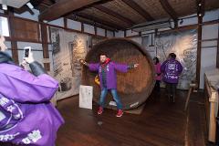 Step Inside a 400-Year-Old Miso Warehouse — The Hatcho Miso Experience in Okazaki, Aichi Visitors explore a historic miso warehouse and a giant barrel while wearing purple jackets.
