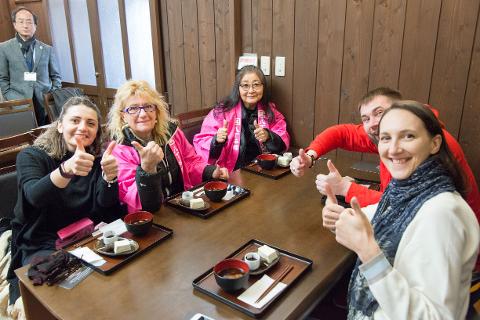 Step Inside a 400-Year-Old Miso Warehouse — The Hatcho Miso Experience in Okazaki, Aichi A group of people happily enjoy a meal and give thumbs up inside a miso warehouse in Okazaki, Aichi.