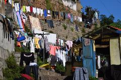 Free Daily Photography Walking Tour In Antananarivo's Historical City Center With Local Guide In this image, laundry hangs on clotheslines against a stone wall, with a small building in the background.