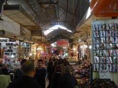 Un marché intérieur animé avec une foule diversifiée d&#39;acheteurs parcourant des étals débordant de marchandises.