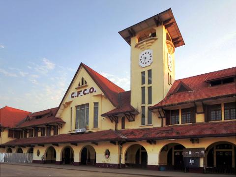 A classic train station with a prominent clock tower stands under a clear sky.
