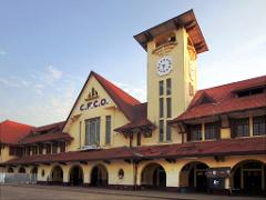A classic train station with a prominent clock tower stands under a clear sky.