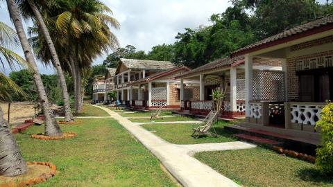 A row of beach bungalows with palm trees in Madagascar.