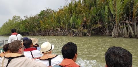 Bangladesh in 7 Days: Dhaka, Sreemongol & the Sundarbans People in a boat are cruising through a mangrove forest on a cloudy day in Bangladesh.