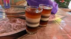 Bangladesh in 7 Days: Dhaka, Sreemongol & the Sundarbans Two layered drinks in clear glasses sit on a patterned table next to a purple cloth.