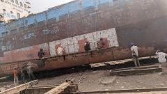 3-Day Dhaka Heritage & Culture Tour — Old Palaces, Lost Cities & Zamindari Mansions Workers on a makeshift platform paint a section of a large, rusted ship docked in a dry dock.
