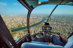 A scenic view of a sprawling city with a river running through it, as seen from the cockpit of a helicopter.