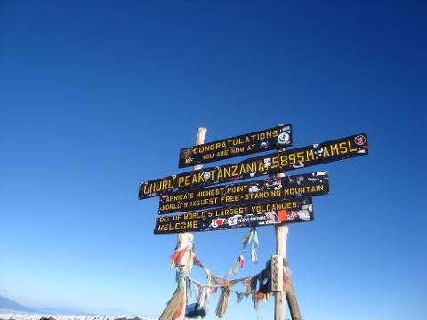 A sign on Mount Kilimanjaro's summit, Uhuru Peak, congratulates climbers, marking it as Africa's highest point at 5895m AMSL.