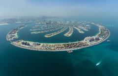 An aerial view of the Palm Jumeirah, an artificial archipelago in Dubai, showcasing its palm-shaped design with luxurious resorts and residential areas.