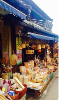 En traditionel japansk butik udstiller et udvalg af håndlavet bambus- og træhåndværk, kurve og souvenirs på en gade med en gammeldags facade.