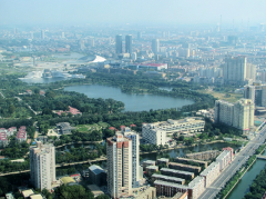 This is an aerial view of a city with a large lake surrounded by trees and buildings.