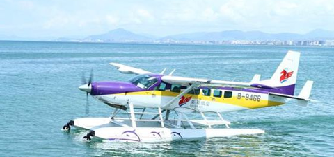 A purple and yellow seaplane is sitting on the water, with its propeller spinning and water splashing.