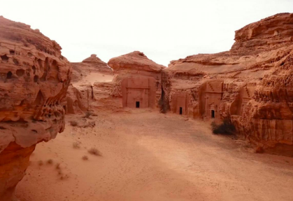 This image shows the ancient Nabataean tombs carved into sandstone cliffs at Hegra (Mada'in Salih) in Saudi Arabia.