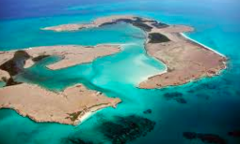 This aerial shot features a collection of sandy islands surrounded by turquoise water, creating a striking contrast between the land and sea.