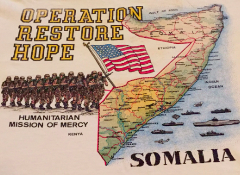 The image depicts a vintage t-shirt design featuring a map of Somalia with "Operation Restore Hope" text, a line of soldiers carrying an American flag, and the phrase "Humanitarian Mission of Mercy."