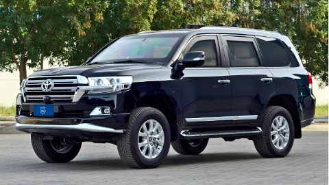 A black Toyota Land Cruiser is parked outdoors with trees visible in the background.