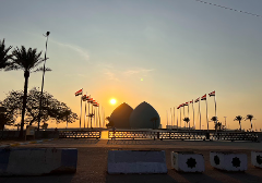 Et malerisk motiv af Martyrmonumentet i Bagdad, Irak ved solnedgang, med landets flag, der vajer i den lette vind.