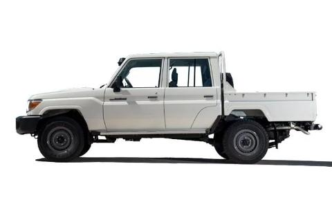 A white double-cab Toyota Land Cruiser pickup truck is seen in profile against a bright white background.
