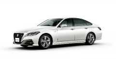 A white Toyota Crown sedan, showcased in a studio setting with a white background, highlights its sleek design and luxurious features.
