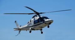 An AgustaWestland AW109 Power helicopter, registration N30EH, is in flight against a clear blue sky.