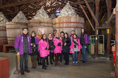 Step Inside a 400-Year-Old Miso Warehouse — The Hatcho Miso Experience in Okazaki, Aichi A group of visitors poses for a photo inside a traditional miso warehouse in Okazaki, Aichi, surrounded by giant wooden barrels filled with miso.