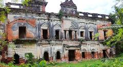3-Day Dhaka Heritage & Culture Tour — Old Palaces, Lost Cities & Zamindari Mansions An abandoned mansion with crumbling walls and overgrown vegetation stands testament to its once grand past.