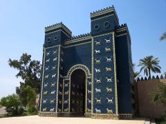 A large, dark blue gate adorned with rows of golden lions and bulls stands proudly under a clear sky.