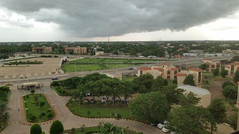 An overcast day over a city with green trees and various buildings.