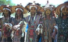 Cure Salee Festival Private Group Package – 7 Days – September A group of men with painted faces and traditional hats and clothing stand together, possibly during the Cure Salée festival.