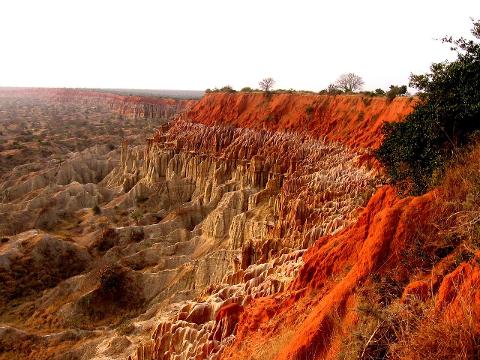 A scenic view of the Moon Valley in Angola with distinctive geological formations and vivid red and tan hues.