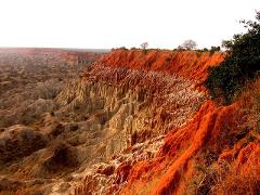 A scenic view of the Moon Valley in Angola with distinctive geological formations and vivid red and tan hues.