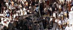 A crowded display of diverse wooden African masks and figurines creates a rich and textured visual experience.