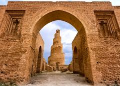 The Great Mosque of Samarra, Iraq, a spiral minaret viewed through a large brick archway.