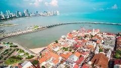 Panama City and Darien Gap An aerial view showcases Panama City, with a modern skyline across the bay from the historic Casco Viejo district and a bridge connecting them.