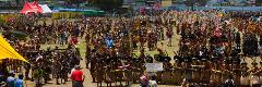 A large crowd of people dressed in traditional clothing and costumes participate in the Goroka Show Festival in Papua New Guinea.