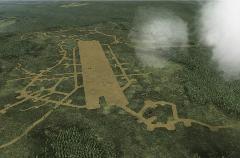 This aerial view depicts a World War II-era airstrip surrounded by trenches and fortifications, set within a lush, forested landscape, likely representing a memorial site.