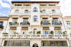 Panama City and San Blas A multi-story, white building with arched windows and balconies displays classic architecture.
